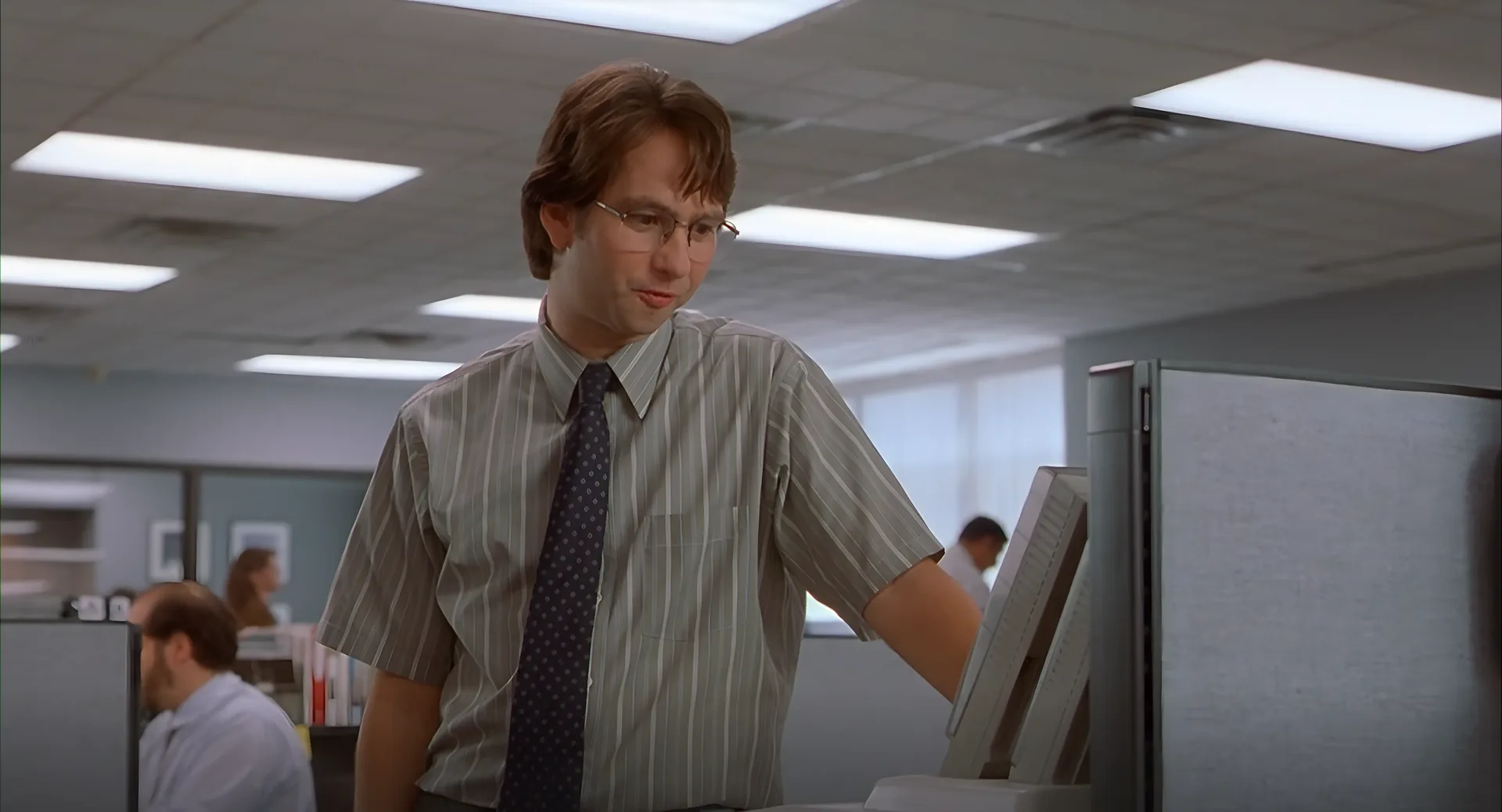 Michael staring down at a beige office monitor, trying to make sense of it.