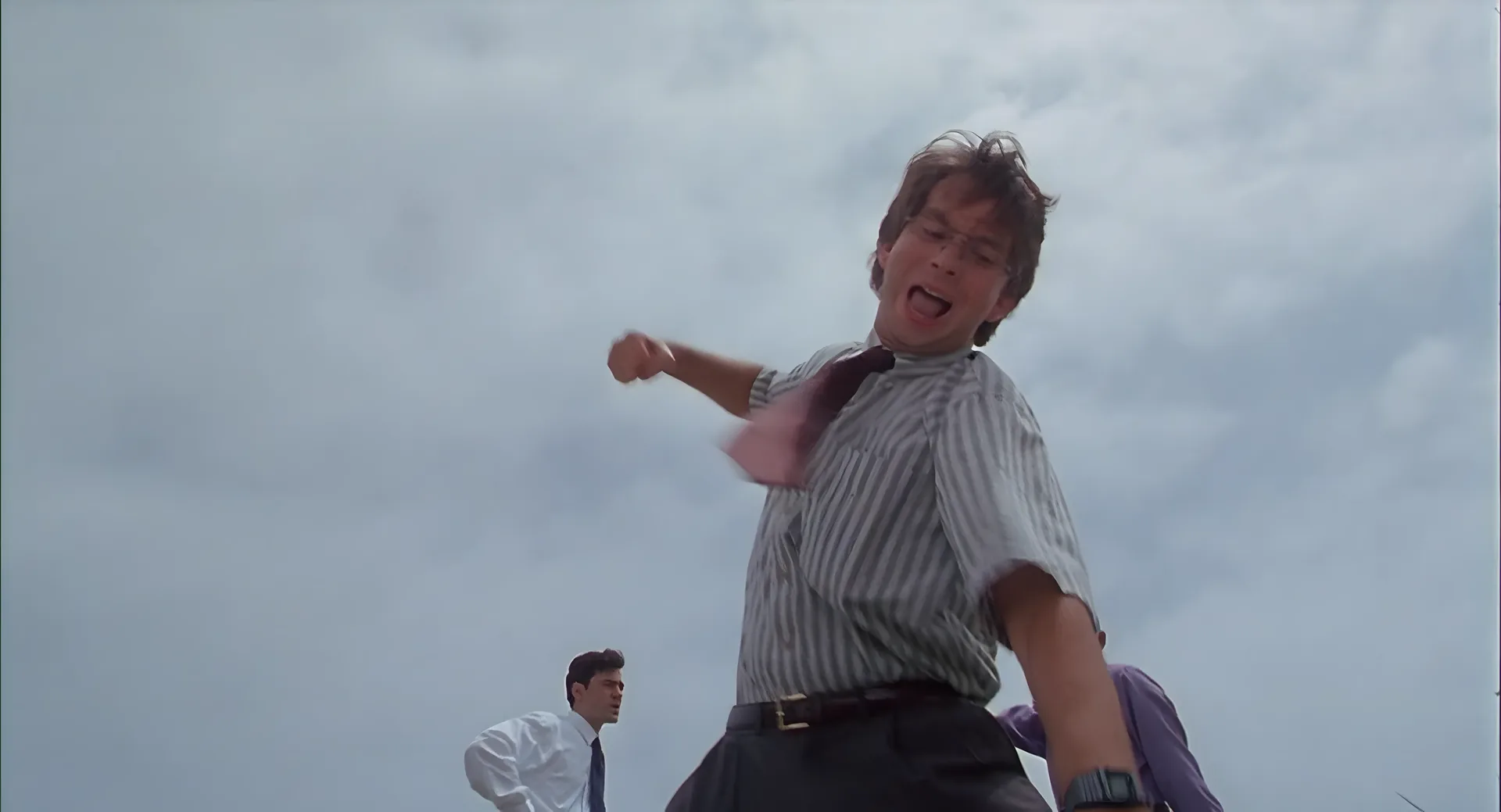 Michael mid-swing in a field, tie flying, destroying the printer.